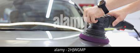 Master polishes car body with polishing machine Stock Photo