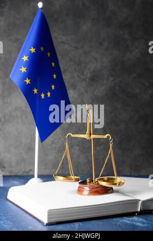 Scales of justice with book and European Union flag on dark background Stock Photo