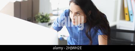 Surprised disgruntled woman looking at computer monitor at workplace Stock Photo