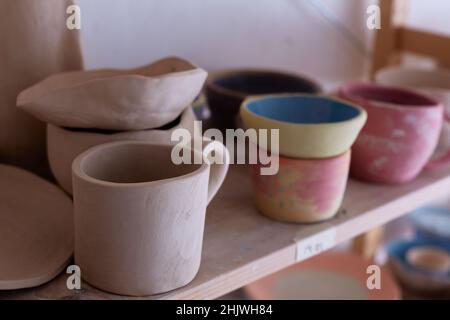 Empty handmade tableware. ceramic cups on the shelf. Handmade work. Stock Photo