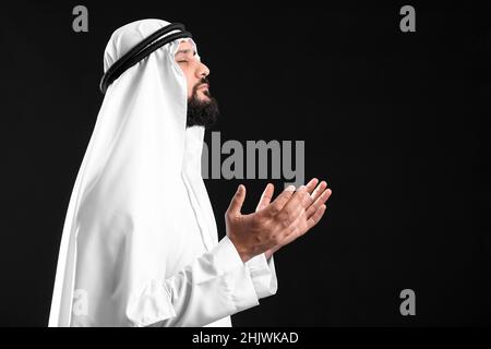 Muslim man praying on black background Stock Photo