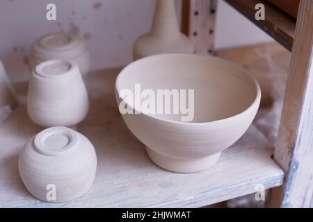 Empty handmade dishes. ceramic bowls on the shelf. Handmade work. The plates are made of clay. Stock Photo