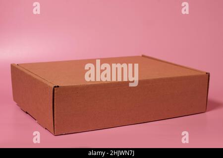 Closed cardboard box on a solid pink background Stock Photo