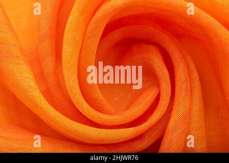 A piece of twisted fabric, orange or yellow, with wonks and wrinkles. Textile. Material Stock Photo