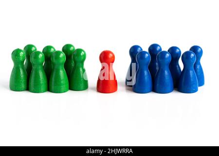 A red game piece in the middle, between two groups of other game pieces in blue and green Stock Photo