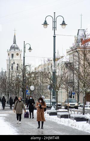 People walking with protective medical mask in Gedimino prospektas in Vilnius centre in winter with snow, vertical Stock Photo