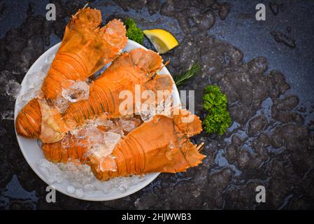 Flathead lobster shrimps on ice, fresh slipper lobster flathead boiled for cooking on white plate lemon parsley in the seafood restaurant kitchen or s Stock Photo