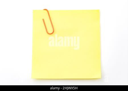 Office memo and reminder note concept with blank self adhesive yellow sticky note with paperclip isolated on white background with copy space and clip Stock Photo