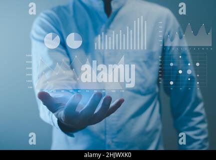 businessman analyzing big data with virtual investment graphs and charts. Stock Photo