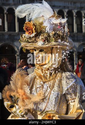 Woman in beautiful golden historic costume fancy dress gown, posing at Carnevale di Venezia, Venice Carnival, Italy Stock Photo