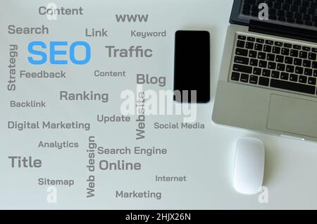 Top view laptop, smart phone and mouse are on the table. SEO and web text concepts on the table. Stock Photo
