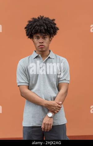 Portrait of serious african american man looking at camera, isolated on salmon color background, Panama, Central America Stock Photo