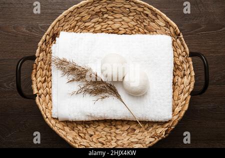 Natural wool dryer balls for more soft clothes while tumble drying in washing machine concept. Earthly tones, reed decoration. Discharge static electr Stock Photo