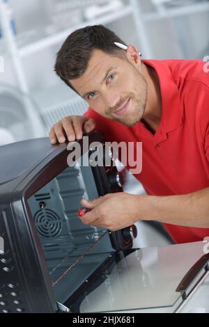 portrait of electrician repairing worktop oven Stock Photo