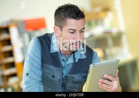 worker checking package by using tablet in warehouse Stock Photo