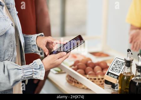 Close-up image of customer scanning qr-code with smartphone to download coffeeshopu on smartphone Stock Photo