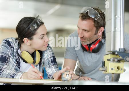 woman watching her manager doing diy carpentry Stock Photo