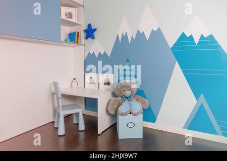 The interior of the boy's room in blue colors, mountains on the walls. Realistic. Stock Photo