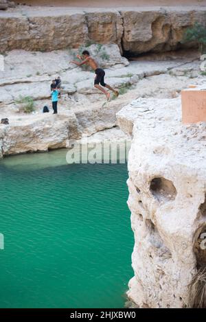 Local People diving to water at Wadi Ash Shab in Oman Stock Photo