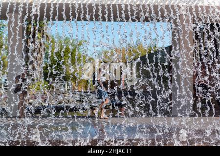 Tourists behind the waterfall of the Water Gardens in the Parque das Nacoes / EXPO 98 in Lisbon, Portugal Stock Photo