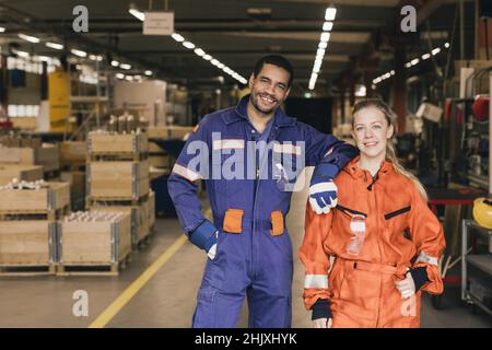 Portrait of smiling male and female coworkers in factory warehouse Stock Photo