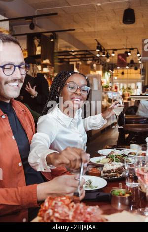 Male and female friends having dinner during part at restaurant Stock Photo