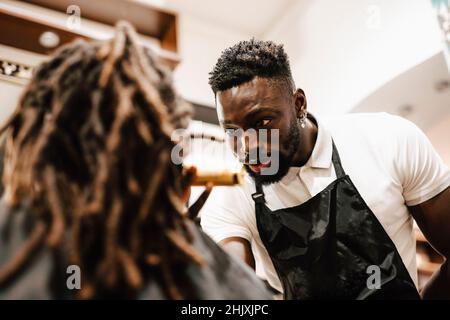 Male hairdresser talking with customer in barber shop Stock Photo