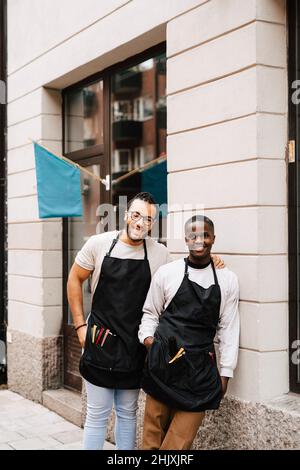 Portrait of male barbers standing outside hair salon Stock Photo