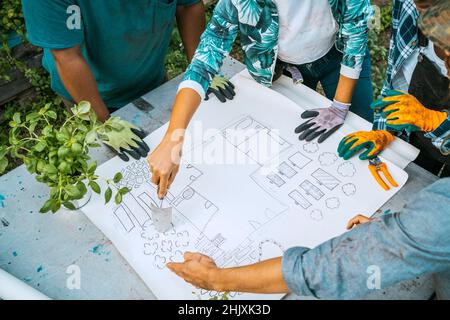 High angle view of male and female farmers examining blueprint in farm Stock Photo