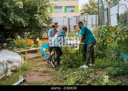Multiracial female and male farmers at table in urban garden Stock Photo
