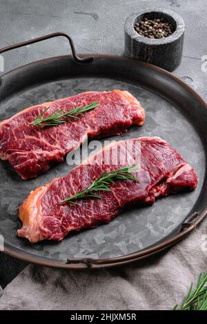 Raw striploin steak set, on black dark stone table background, top view ...