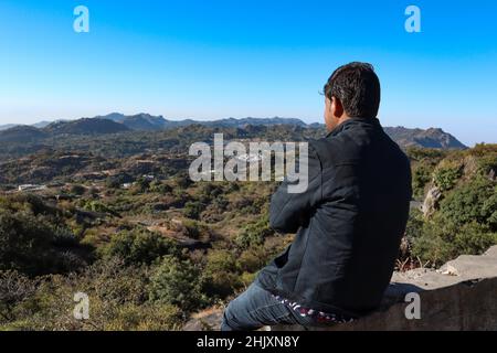 Mount Abu, Rajasthan, India- December 28, 2020: Hiker young boy over looking Aravalli Range with Mount Abu, Rajasthan. Stock Photo