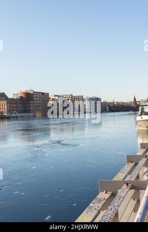 Berlin, Germany - December 26, 2021: view of the other shore from the Spree river embankment between the Oberbaunum bridge and Elsen Bridge Stock Photo