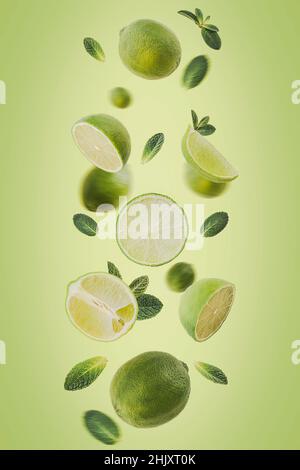 Levitating Lime slices with leafs on a green background. Selective focus. Toned image Stock Photo