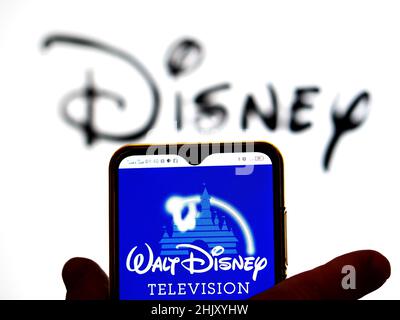 In this photo illustration, the FX Networks logo is displayed on a  smartphone screen with a Disney logo in the background Stock Photo - Alamy