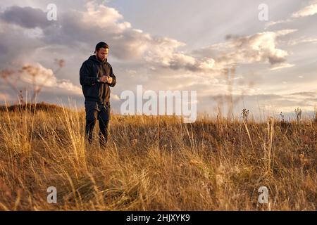 Handsome guy in black wear having rest outdoors, in nature. Male after sport, enjoy the rest. Relaxed man jogger, leisure after training. outdoor port Stock Photo