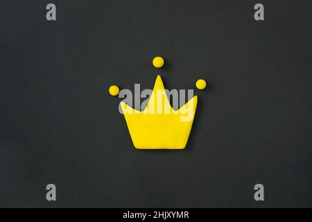 Simple 3d yellow crown symbol on black background. Concept of win and success, top rank quality status. Stock Photo