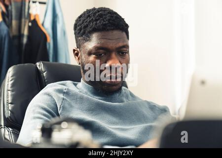 Sad focused black afroamerican man working on computer laptop - portrait shot. High quality photo Stock Photo