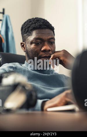 Focused thinking black man working on laptop computer - portrait shot. High quality photo Stock Photo