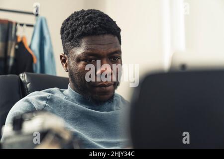 Focused black man working in home on tablet pc - close up shot. High quality photo Stock Photo