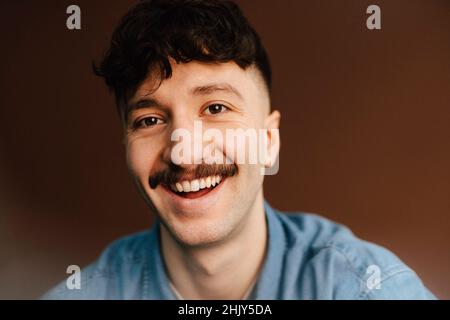 Portrait of happy man over brown background in studio Stock Photo