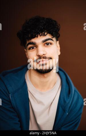 Portrait of young man over brown background Stock Photo