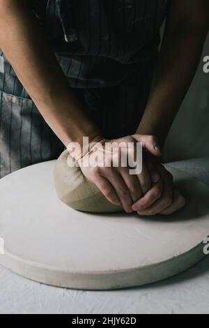 Midsection of craftswoman kneading clay in workshop Stock Photo