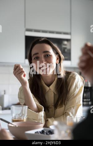 Portrait of smiling woman having breakfast at table Stock Photo