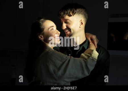 Smiling couple looking at each other with sunlight on faces Stock Photo