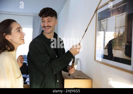 Happy young couple with tape measure standing in new house Stock Photo