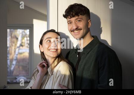 Portrait of smiling man standing with girlfriend at home Stock Photo