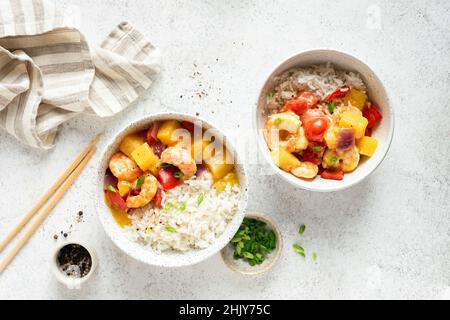 White rice in bowl with pineapple shrimp curry on grey concrete table background, top view Stock Photo