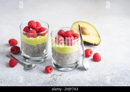 Vegetarian Chia seed pudding with raspberries and avocado mousse layer. Healthy dessert in jar, sugar free gluten free rich in omega 3 fatty acids Stock Photo