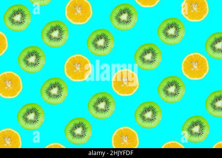 Fruits slices pattern, top view of kiwi and lemon slices isolated on blue background. Stock Photo